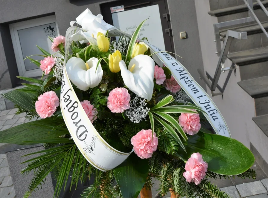 Wiązanka pogrzebowa z różowych goździków, białych kalii i tulipanów z szarfą