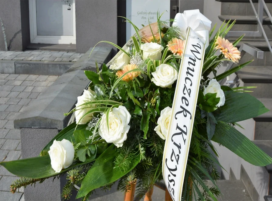 Wiązanka pogrzebowa z białych róż i łososiowych gerber z szarfą